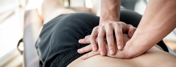 Physical therapist giving massage and stretching athlete - Mike Munro